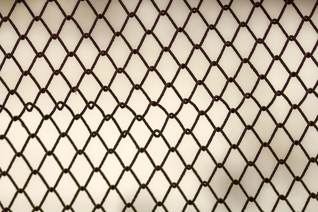 背景とデザインのテクスチャ 汚れた灰色の壁に対して抽象的なチェーンリンクフェンスのテクスチャです プレミアム写真