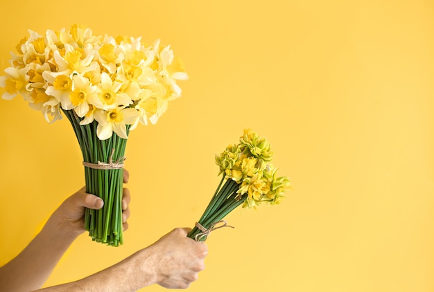 花の花束と背景の男性の手 無料の写真