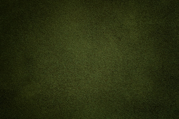 ダークグリーンのスエード生地のクローズアップの背景 オリーブヌバックテキスタイルのベルベットマットテクスチャ プレミアム写真