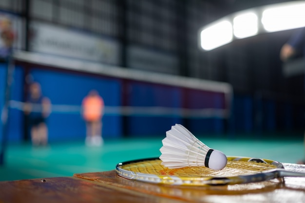 Premium Photo Badminton Shuttlecock And Racket With Blur Player Background