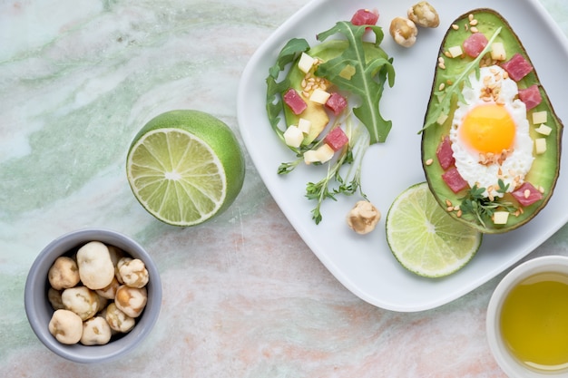 Premium Photo Baked Avocado Boat With Ham Cubes Quail Egg And Cheese Served With Green Rucola 8550