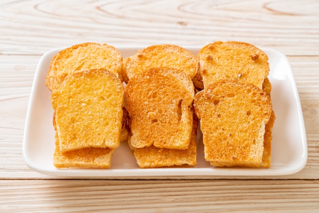 Premium Photo Baked Crispy Bread With Butter And Sugar On Plate