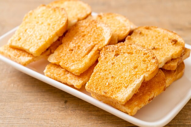 Premium Photo Baked Crispy Bread With Butter And Sugar On Plate