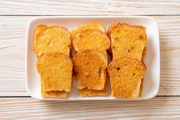 Premium Photo Baked Crispy Bread With Butter And Sugar On Plate