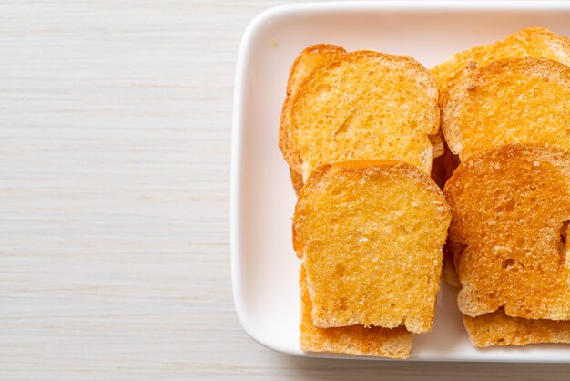 Premium Photo Baked Crispy Bread With Butter And Sugar On Plate