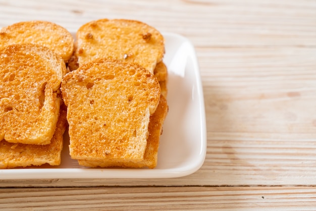 Premium Photo Baked Crispy Bread With Butter And Sugar On Plate