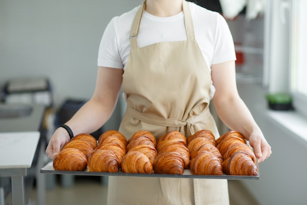 Premium Photo Baker Carrying Freshly Baked Crispy Golden Croissants