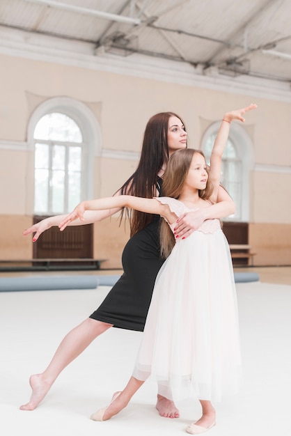 バレリーナインストラクターと女の子 ダンススタジオでポーズをとる 無料の写真