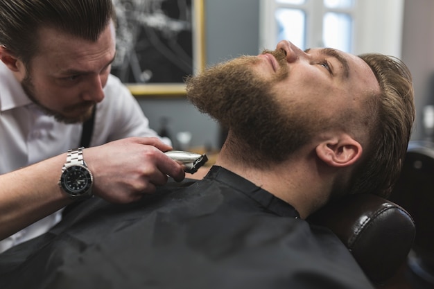 Barber shaving neck of customer Free Photo