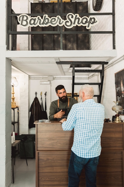 Barber Talking With Client At Reception Desk Free Photo