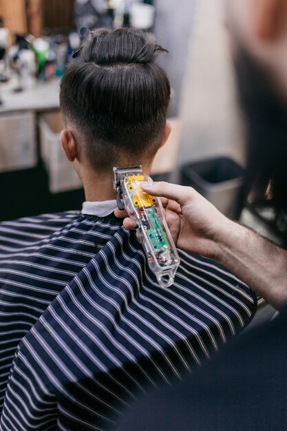 Premium Photo | Barber using hair clipper and comb to cut the hair in