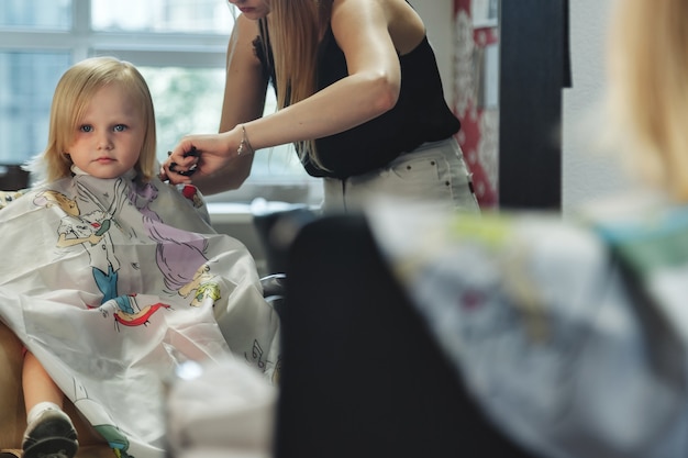 Premium Photo | Barber woman make fashionable pretty hairstyle for cute ...