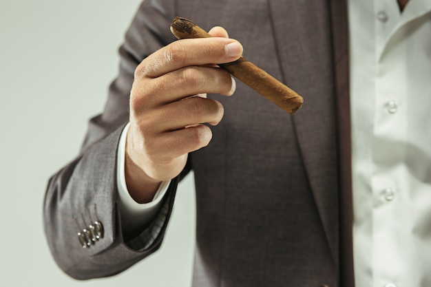 The barded man in a suit holding cigar Free Photo