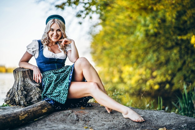 Premium Photo Barefoot Happy Pretty Blond Girl In Dirndl Traditional Beer Festival Dress Sitting Outdoors With Blured Colorful Trees Behind Neither had nothing on their feet.sally: https www freepik com profile preagreement getstarted 9278413