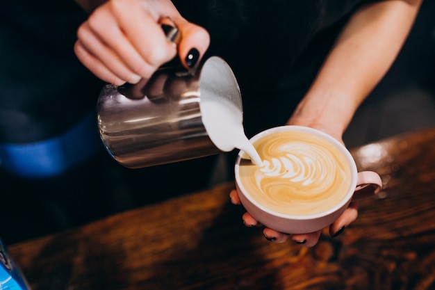 Free Photo Barista Pouring Milk Into Coffee In A Coffee Shop