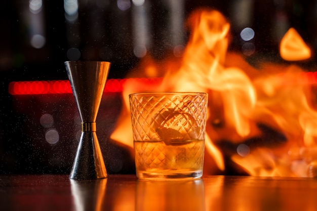 Premium Photo | The bartender makes flame over a cocktail with orange ...