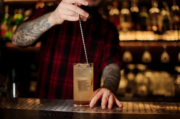 Premium Photo | Bartender stirring a lemonade cocktail with the spoon ...