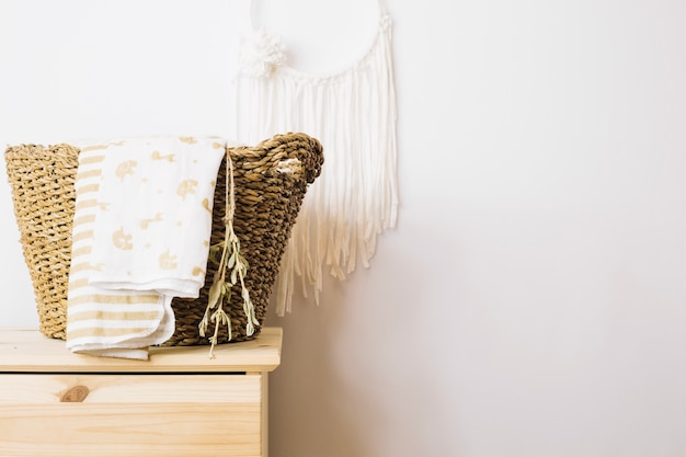 Basket with blankets near wall decoration Free Photo