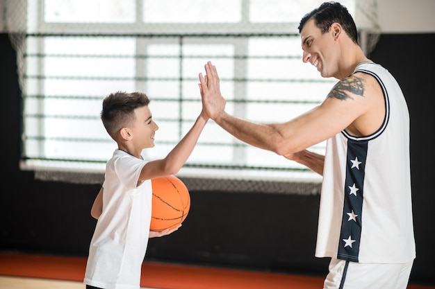 Premium Photo | Basketball. Coach In White Sportswear And A Boy With A ...