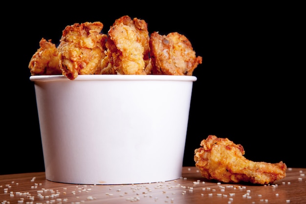 Premium Photo | Bbq chicken wings in a white bucket on a wooden table ...