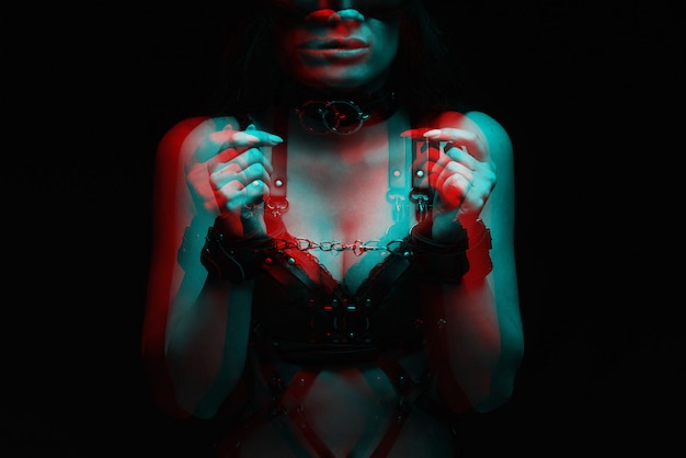 緊縛 手錠とセクシーな黒革の下着の女の子をクローズアップ プレミアム写真