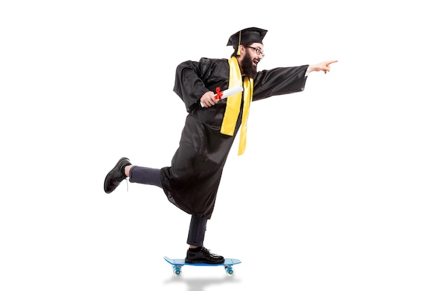 Premium Photo | Bearded hipster graduate riding a skateboard, pointing ...