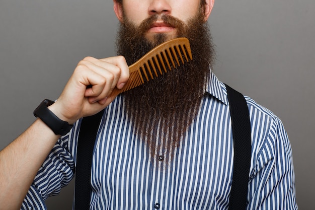 Premium Photo Bearded Man Combing His Long Beard