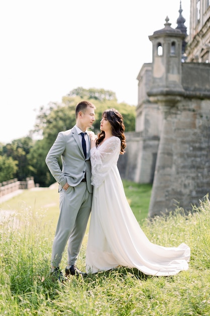 Premium Photo Beautiful Asian Couple Woman In Wedding Dress Man In Suit Posing Outdoors Near The Old Ancient Castle