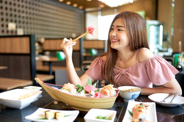 beautiful asian woman eating sashimi japanese food 9486 10 - Berapa Total Biaya Hidup Mahasiswa di Malaysia? Cek di Sini
