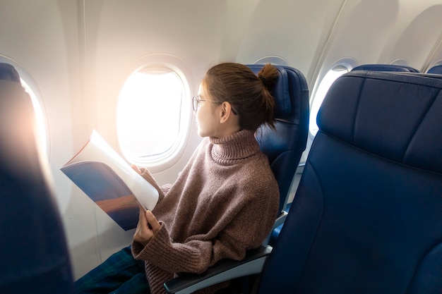 Beautiful Asian Woman Is Reading Magazine In Airplane | Premium Photo