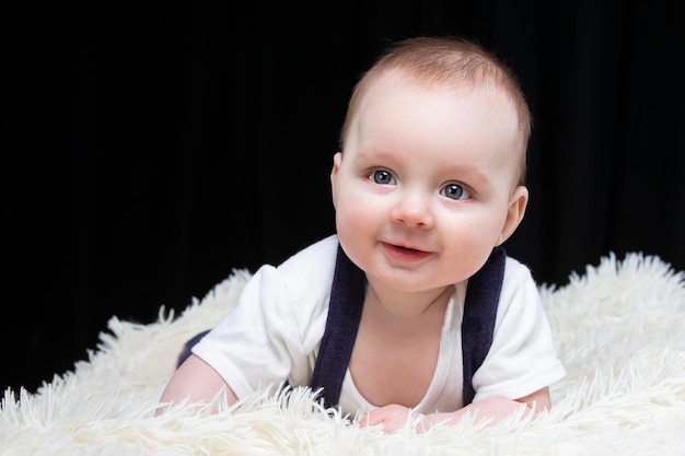Premium Photo | Beautiful baby boy smiles and looks into the camera ...