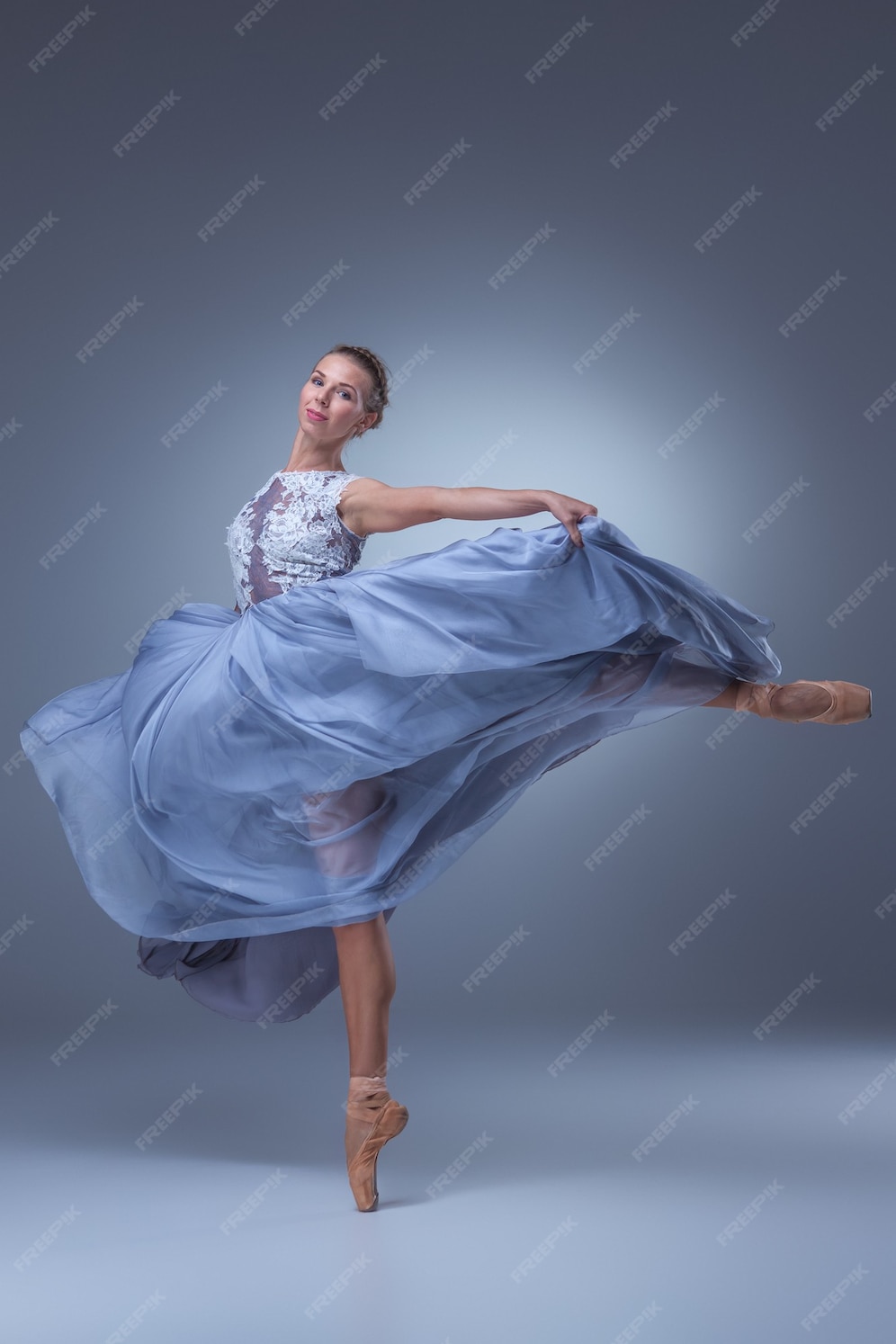 Free Photo | Beautiful ballerina dancing in long blue dress on blue