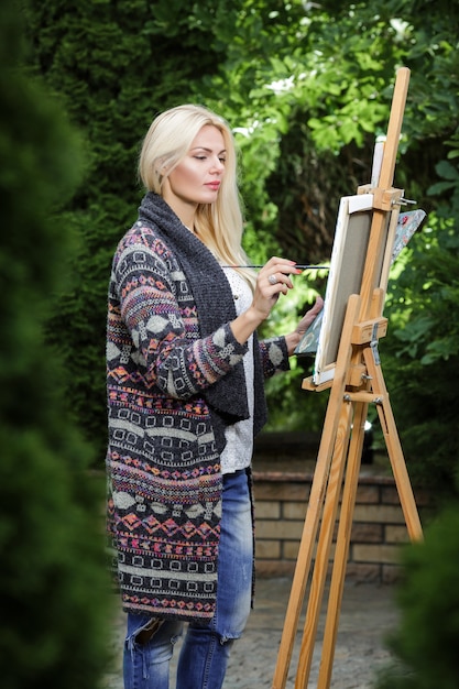 Premium Photo Beautiful Blonde Woman Artist With A Brush In Her Hand