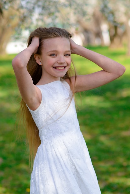 Premium Photo Beautiful Blue Eyed Girl With Long Blond Hair In A White Dress Walking In The Flower Garden Summer Bright Emotional Photo