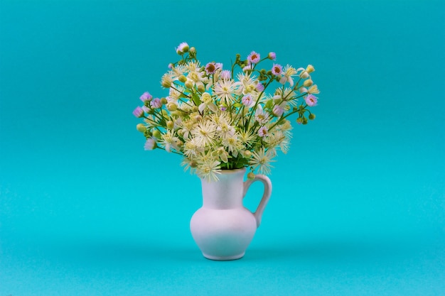 Premium Photo Beautiful Bouquet Of Wild Flowers In A White Jug On Blue