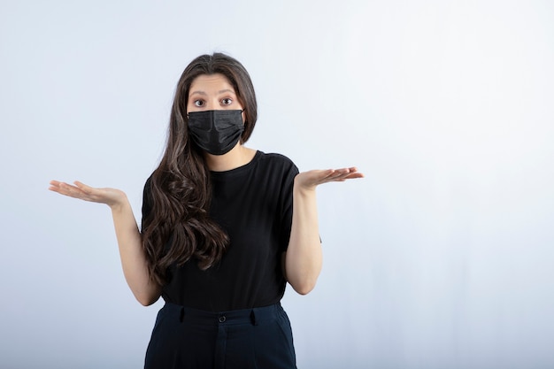Premium Photo Beautiful Brunette Girl In Black Medical Mask Standing And Posing Against White