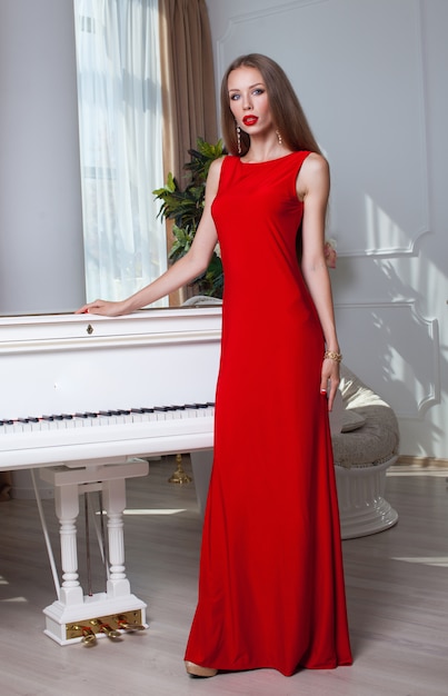 Premium Photo | Beautiful brunette woman in a red dress.