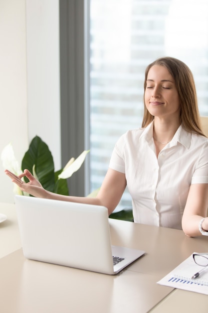 Free Photo | Beautiful businesswoman meditating in office