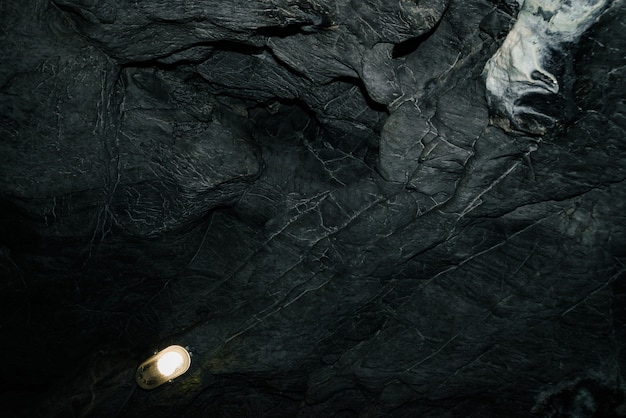 美しい洞窟 暗いダンジョンの中からの眺め 洞窟のテクスチャ壁 地下トンネルの背景画像 洞窟の中の湿気 遠足用の洞窟内の照明 プレミアム写真