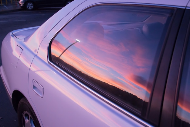 紫の車の窓に映る夕焼けの美しい色 無料の写真