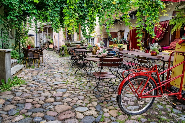 Beautiful corner with a retro atmosphere with tables, chairs and an old bicycle. Premium Photo