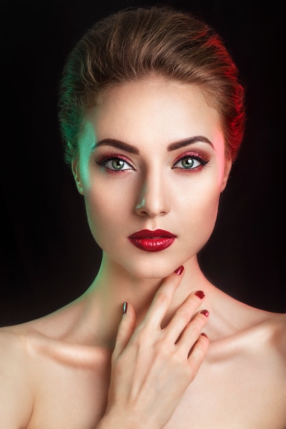 Beautiful elegant young model with red lips and color evening make-up. Premium Photo