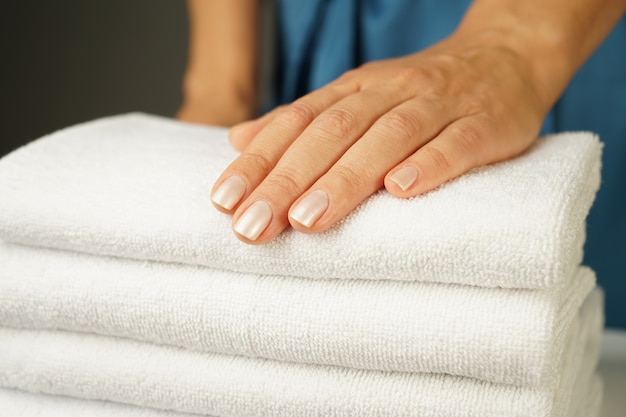 Premium Photo A Beautiful Female Hand Lies On A Neatly Folded Stack Of White Terry Towels