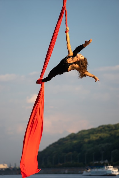 Premium Photo Beautiful And Flexible Female Circus Artist Dancing With Aerial Silk With Sky