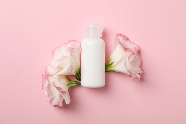 Premium Photo | Beautiful flowers and blank bottle on pink background ...