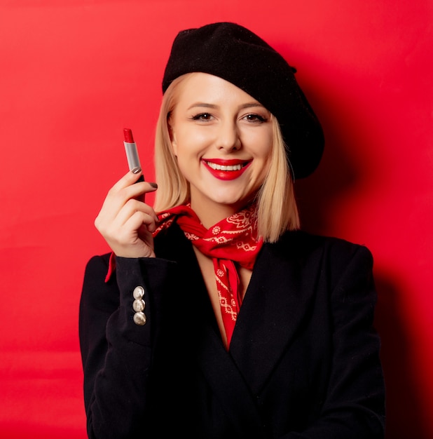 Premium Photo Beautiful french woman in beret with lipstick on red wall