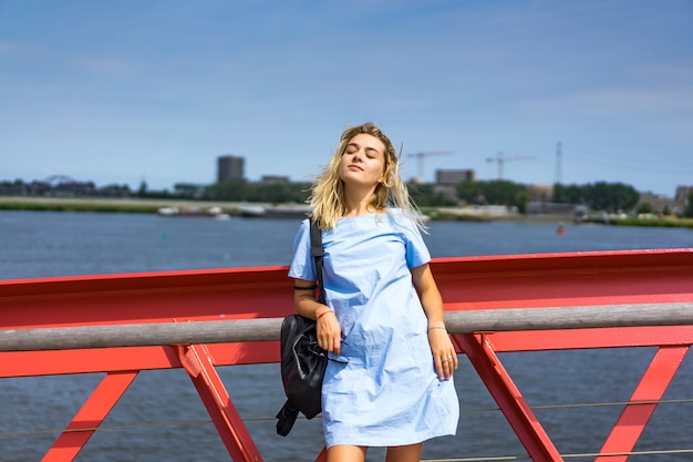 Beautiful girl in a blue dress posing on the bridge Free Photo