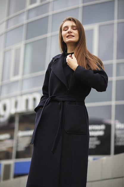 Premium Photo | Beautiful girl in a coat in business downtown of the cloudy