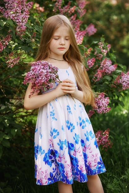 Premium Photo Beautiful Girl In A Dress Posing Near A Bush Of Lilacs