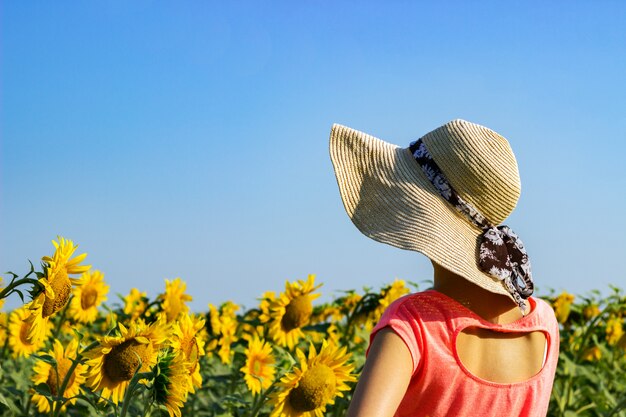 Premium Photo | Beautiful girl in a hat among a sunflower